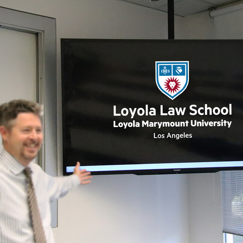 An LLS staff member presenting the new logo on a large television monitor